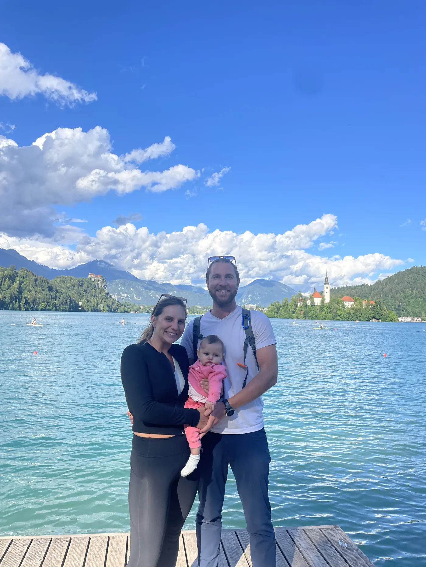 Colin and Angela holding Andi on a dock at Lake Bled