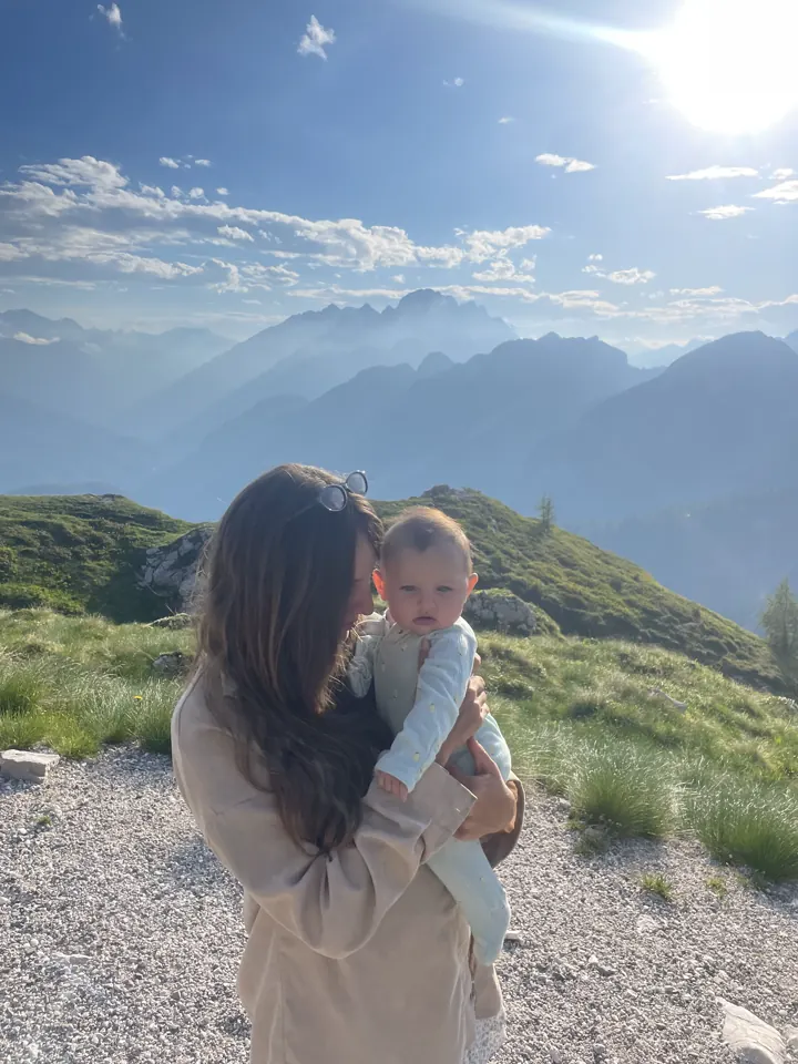 Angela holding Andi with mountains in the distance