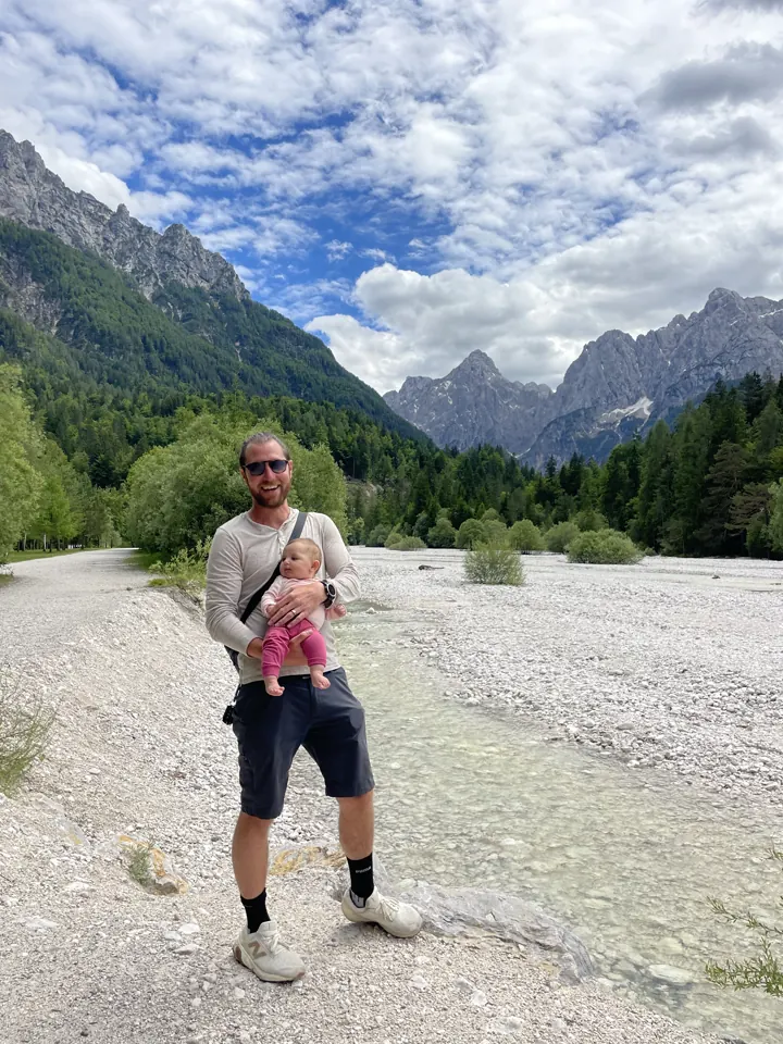 Colin carrying Andi on a white riverbed in the Julian Alps