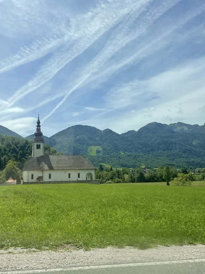 A small church in a green field in the Soča Valley