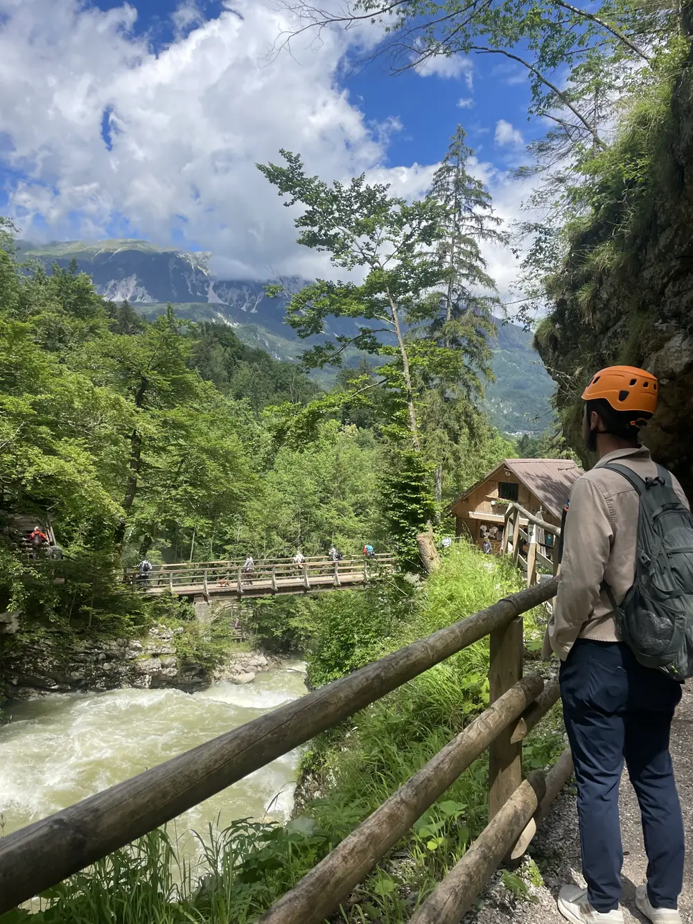 A wooden boardwalk along a rushing river in a forested gorge