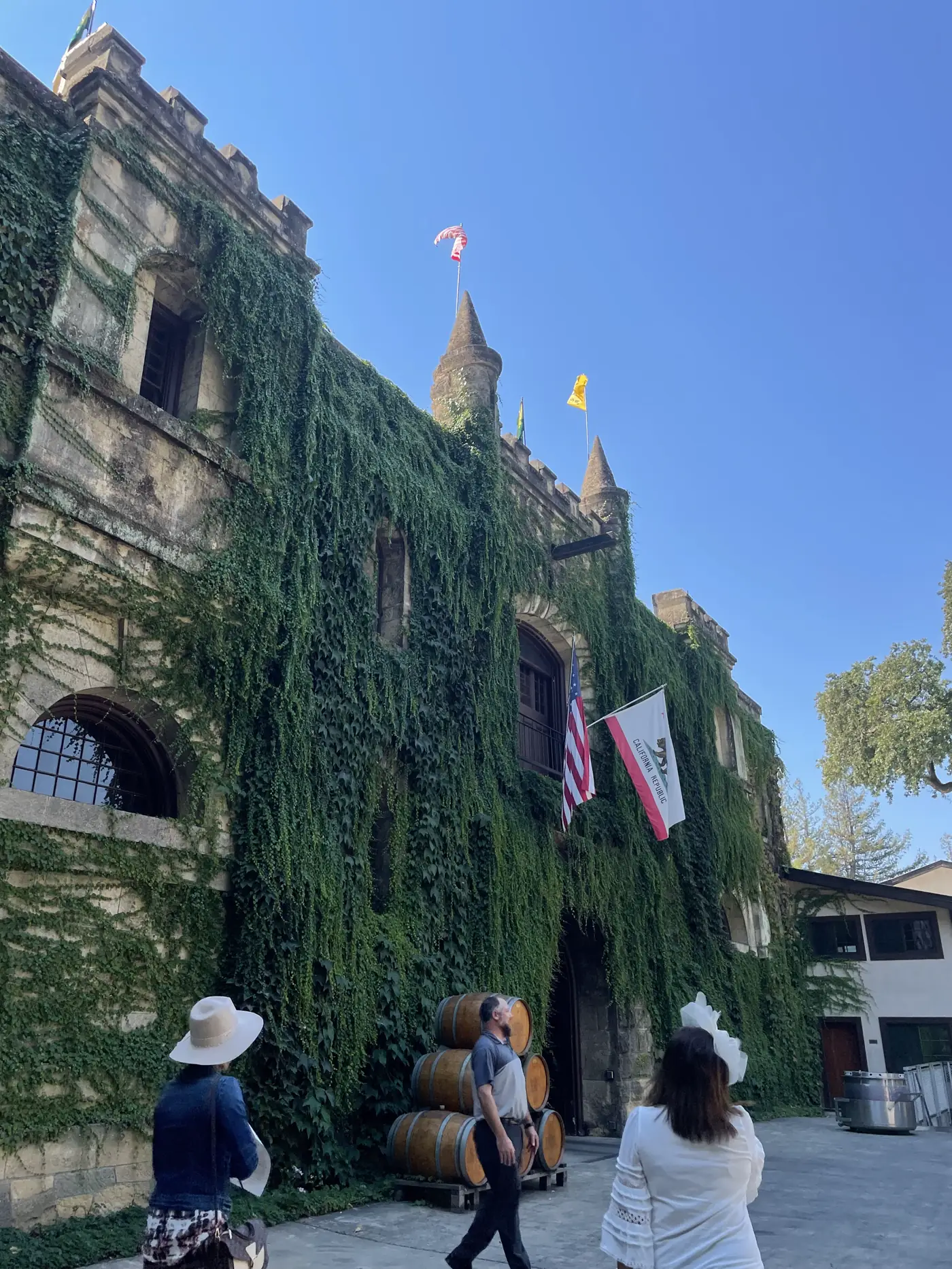 An ivy-covered stone castle winery with flags in Calistoga