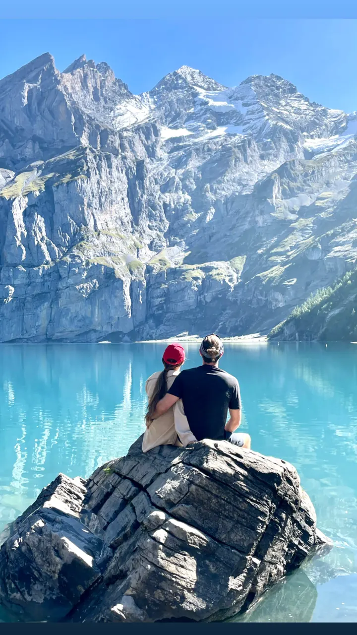 Colin and Angela sitting on a rock above the turquoise Oeschinensee