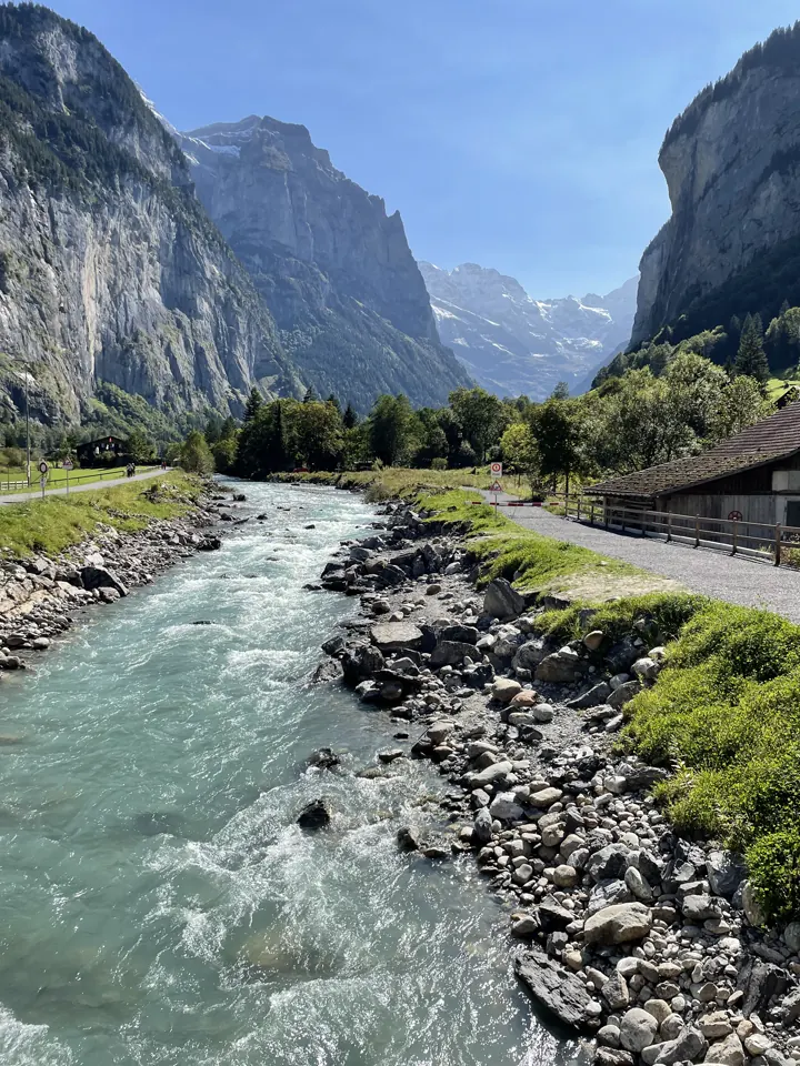 Rushing glacial river through the Lauterbrunnen valley below cliffs