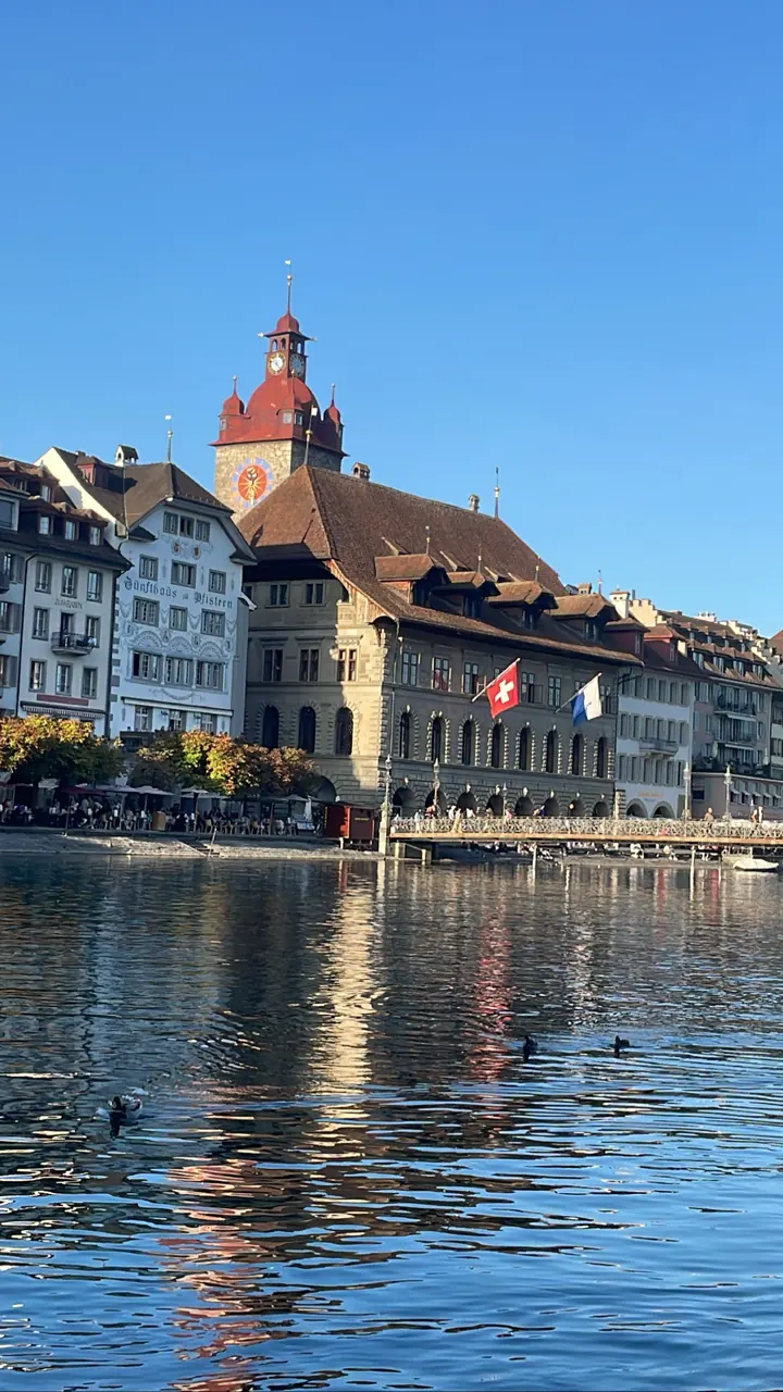Old buildings and a clock tower reflected in the river