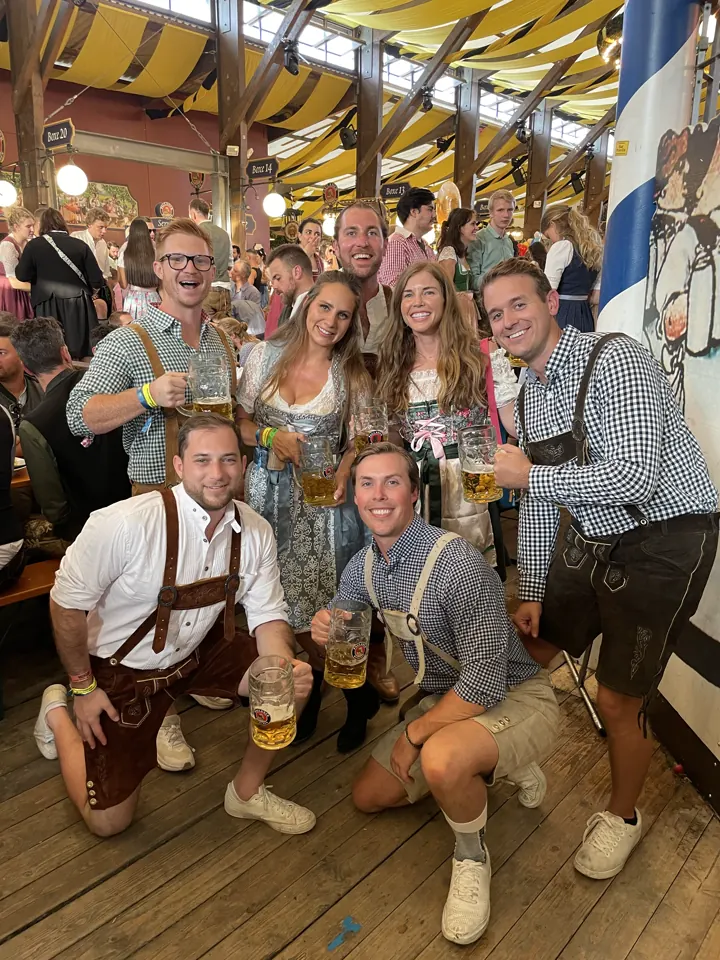 Big group of friends in traditional outfits posing in a beer tent